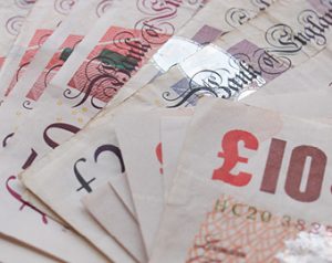 the image shows a stack of English currency notes spread as a fan.